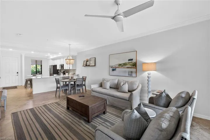 Open-concept living area with tile flooring and crown molding