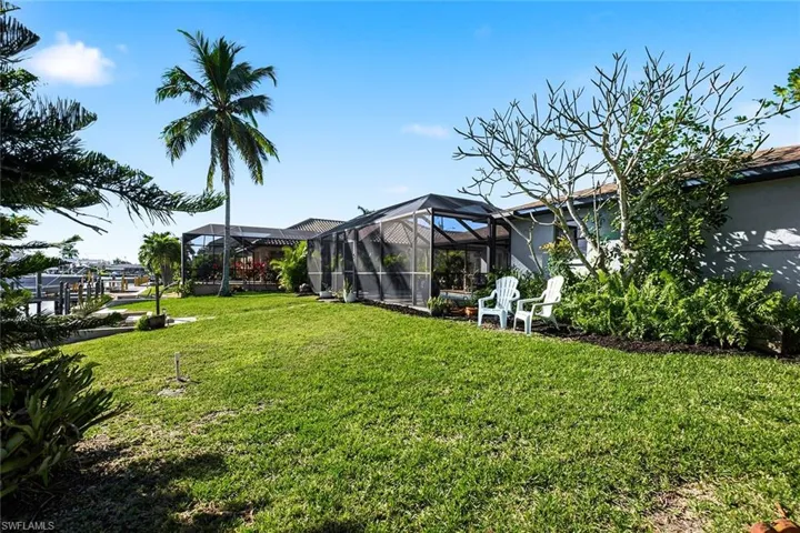 View of green lawn featuring a lanai and a sunroom