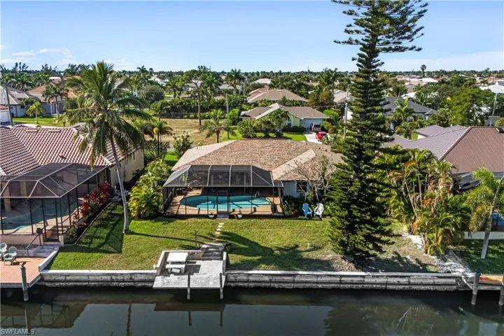 Aerial perspective of suburban area featuring a nearby body of water and a pool area