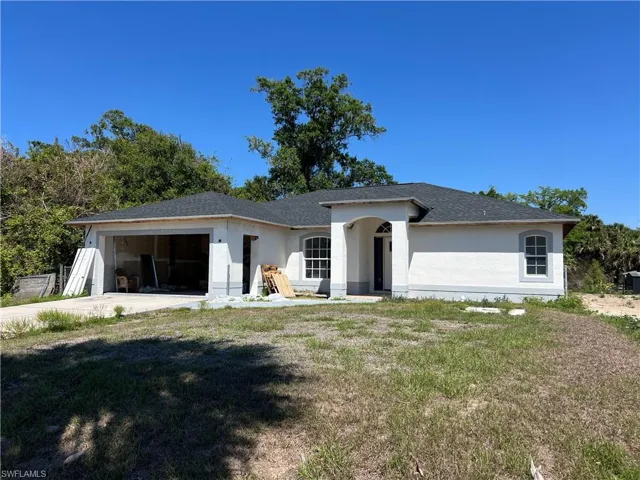 Single story home with a garage, a front yard, stucco siding, and concrete driveway