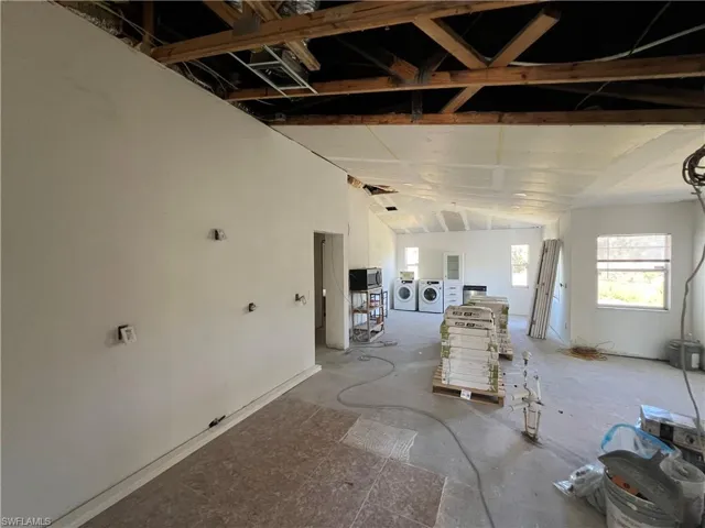 Miscellaneous room featuring washer and clothes dryer and vaulted ceiling