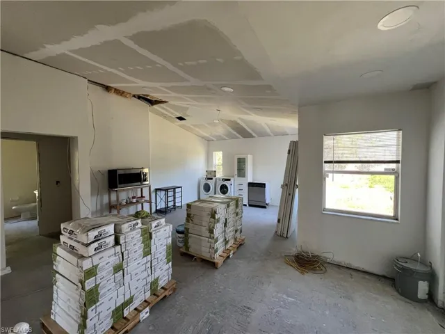 Living room with washer and clothes dryer