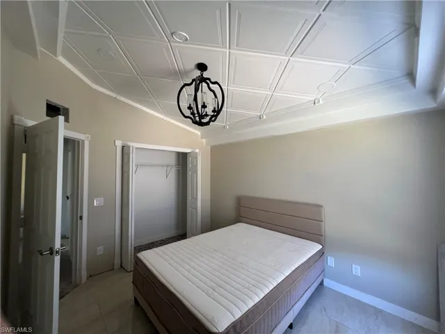 Bedroom with an ornate ceiling, a closet, and suspended lighting
