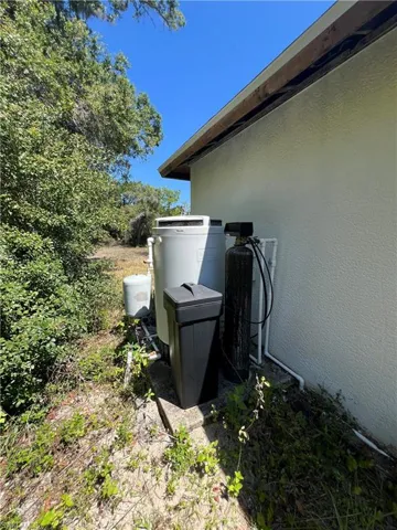 Exterior view of stucco siding and a water softener