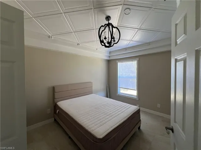 Bedroom featuring baseboards and an ornate ceiling