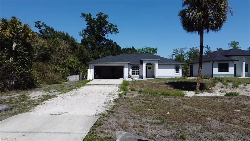 Single story home featuring driveway, an attached garage, and stucco siding