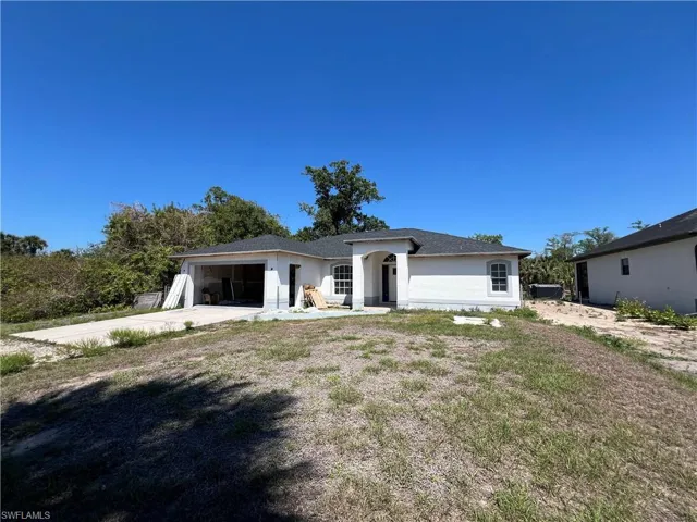 View of front of house featuring an attached garage, stucco siding, and concrete driveway