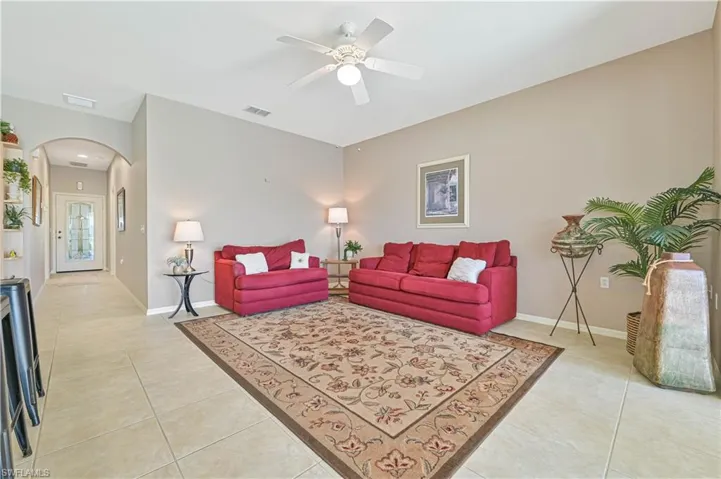 Living room featuring light tile patterned floors and ceiling fan