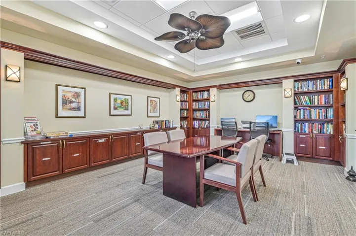 Dining area with light carpet, ceiling fan, and a tray ceiling