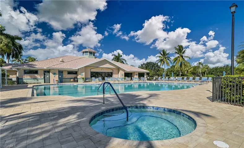View of swimming pool with a hot tub