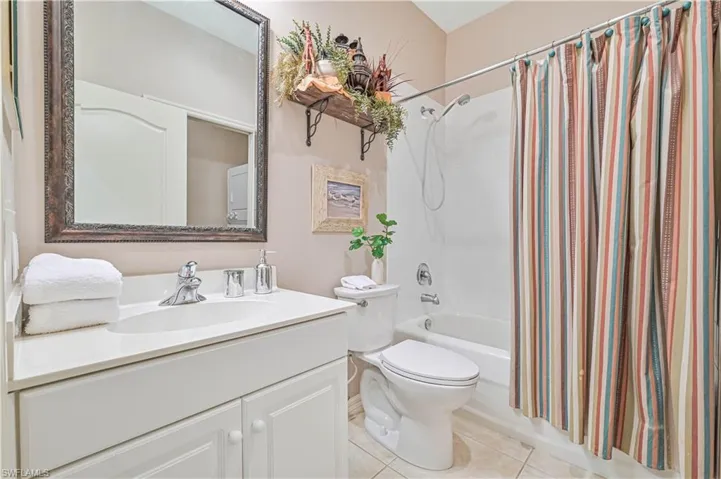 Full bathroom featuring tile patterned floors, vanity, toilet, and shower / bath combination with curtain