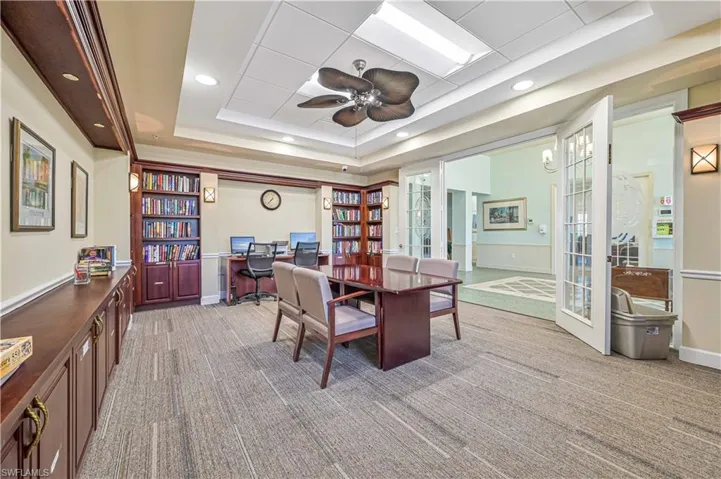 Carpeted dining space with ceiling fan, french doors, and a tray ceiling