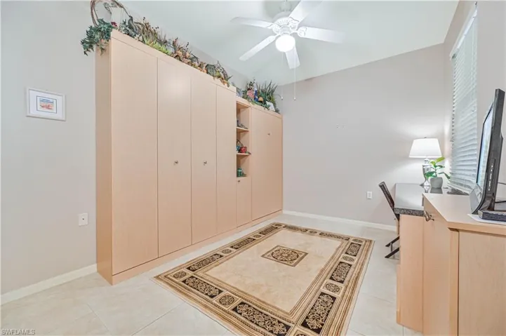 Office with light tile patterned flooring and ceiling fan