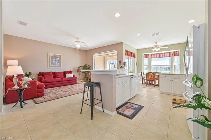 Kitchen featuring white cabinets, a kitchen breakfast bar, light tile patterned floors, and ceiling fan