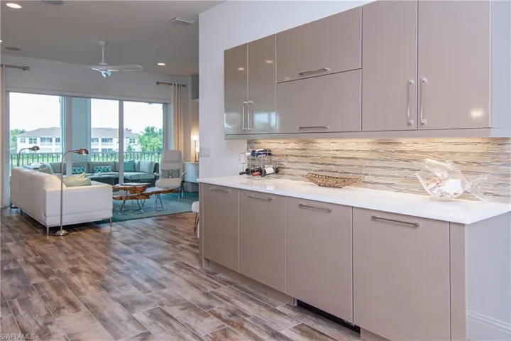 Custom built cabinets in galley with beverage fridge opposite dining room.