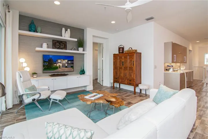 Great room looking toward primary bedroom entry.  Custom built-in galley in spacious hallway opposite dining room.