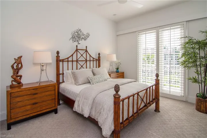 Bedroom 2 with plantation shutters on french doors leading out to balcony.  Retractable screen for ventilation.  All bedrooms have en-suite baths.