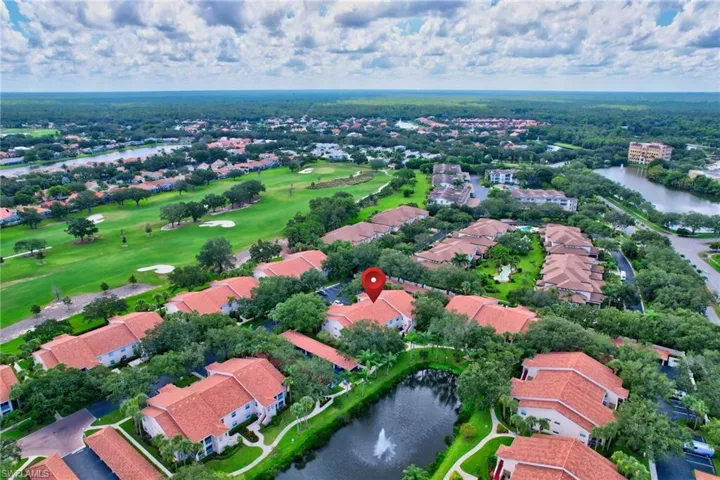 Aerial perspective of suburban area with a nearby body of water and a golf club