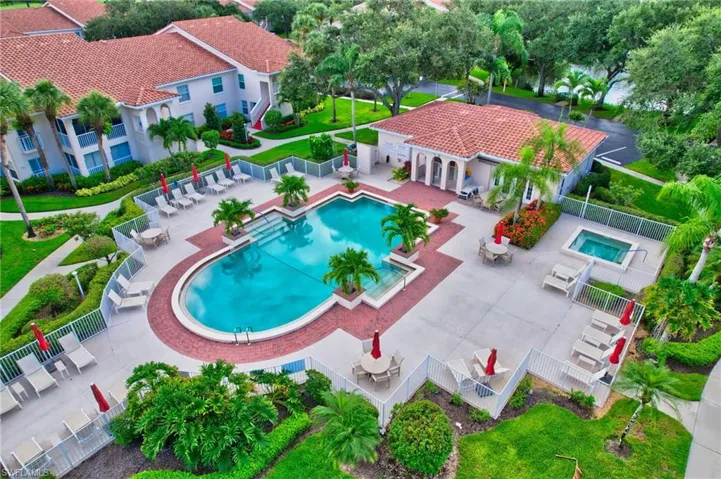 Community pool featuring stairs, a patio area, and a hot tub