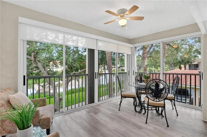 Sunroom / solarium with plenty of natural light, wood finished floors, and a water view