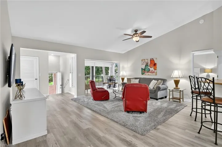 Living room featuring vaulted ceiling, light wood finished floors, and a ceiling fan