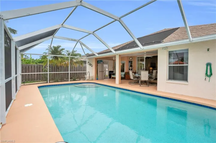 View of pool with a patio, ceiling fan, and glass enclosure