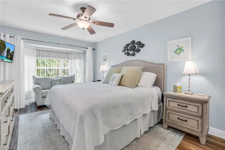Bedroom with ceiling fan and hardwood / wood-style floors