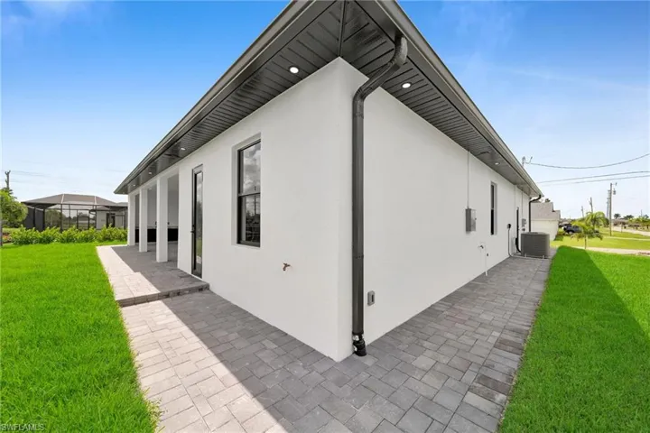 View of property exterior featuring a yard, central AC, and a patio area