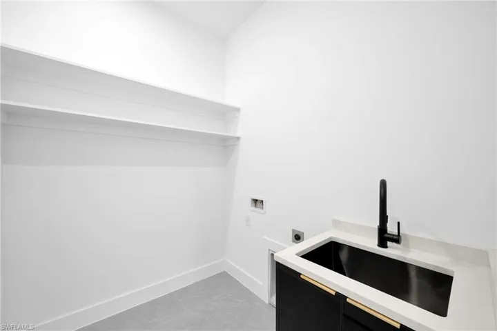 Laundry room featuring sink, hookup for an electric dryer, washer hookup, and light tile patterned floors