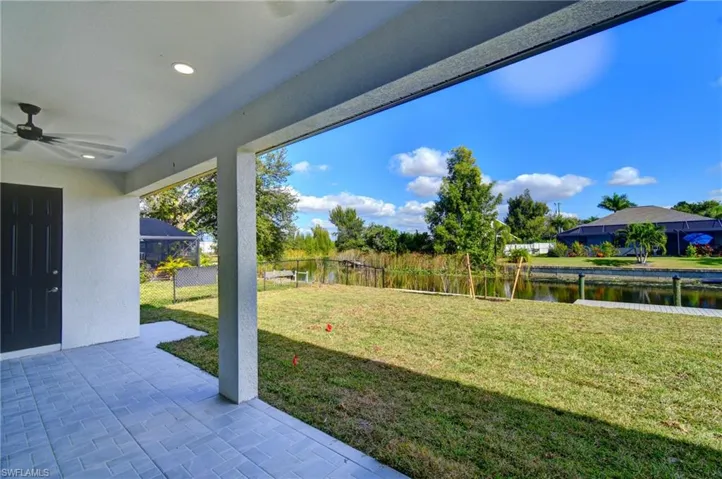 View of yard featuring a ceiling fan, a water view, and a patio