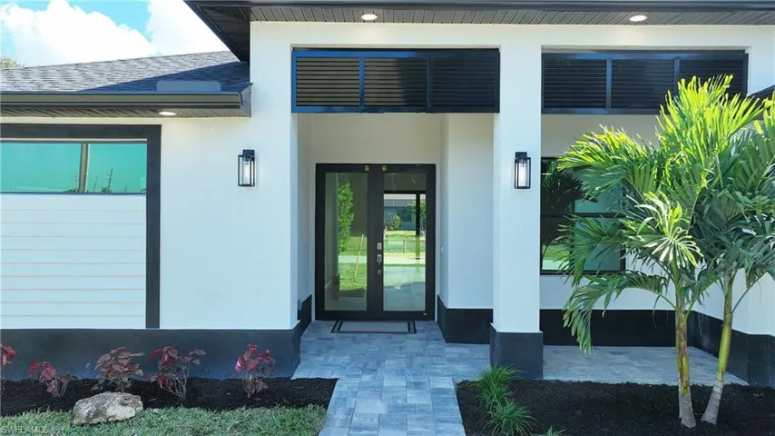 Property entrance with stucco siding and a shingled roof