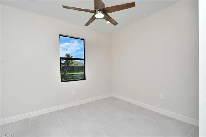 Unfurnished room with light tile patterned flooring and ceiling fan
