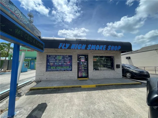 View of commercial property featuring uncovered parking