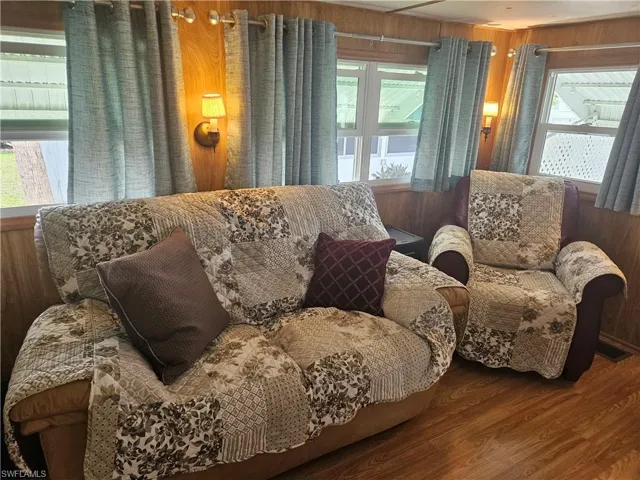Living area with wood finished floors and wooden walls