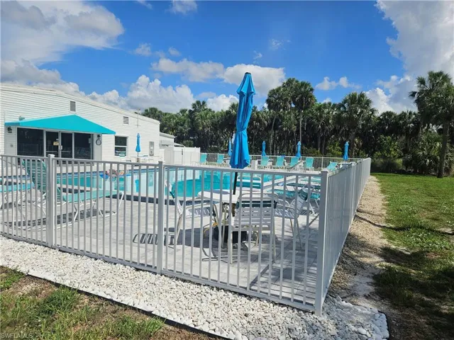 Community pool featuring a patio area and view of wooded area