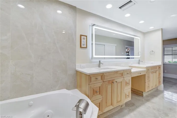 Bathroom with vanity and a bath