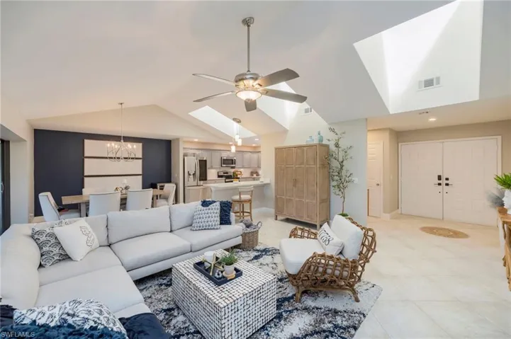 Living area featuring a skylight, hanging lights, and ceiling fan