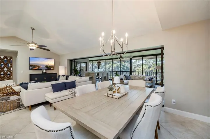 Dining room featuring lofted ceiling, hanging lights, a ceiling fan, and light tile patterned floors