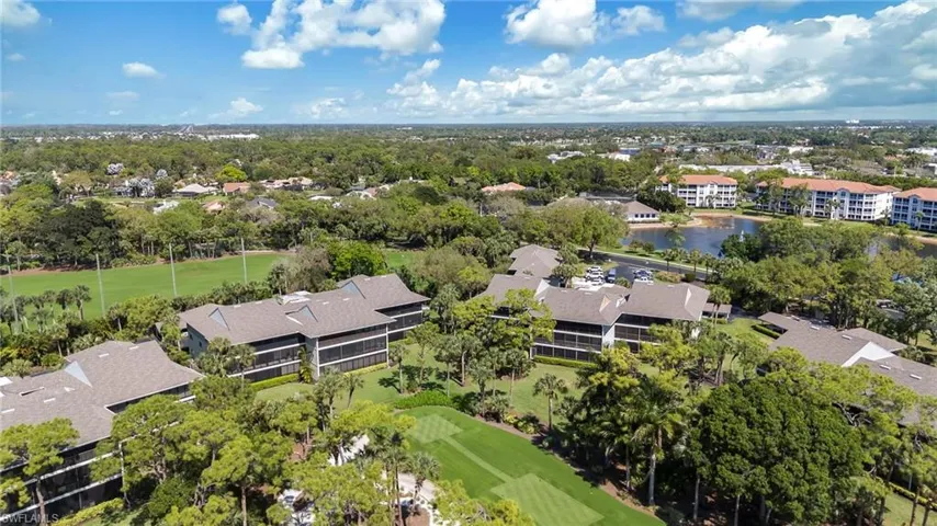 Aerial view of residential area featuring a golf course and a large body of water