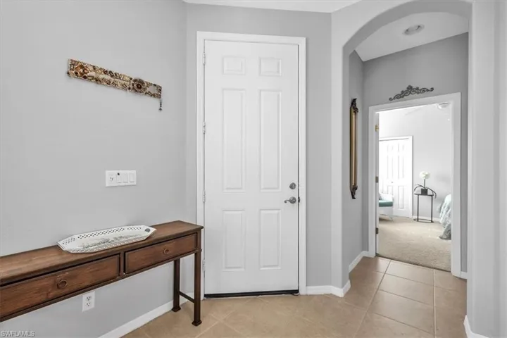 Entryway with light tile patterned flooring and arched walkways