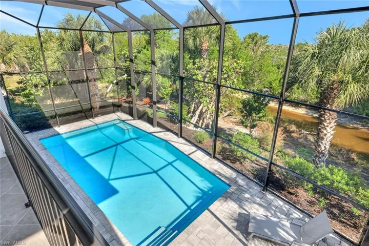 Swimming pool featuring glass enclosure and a sunroom