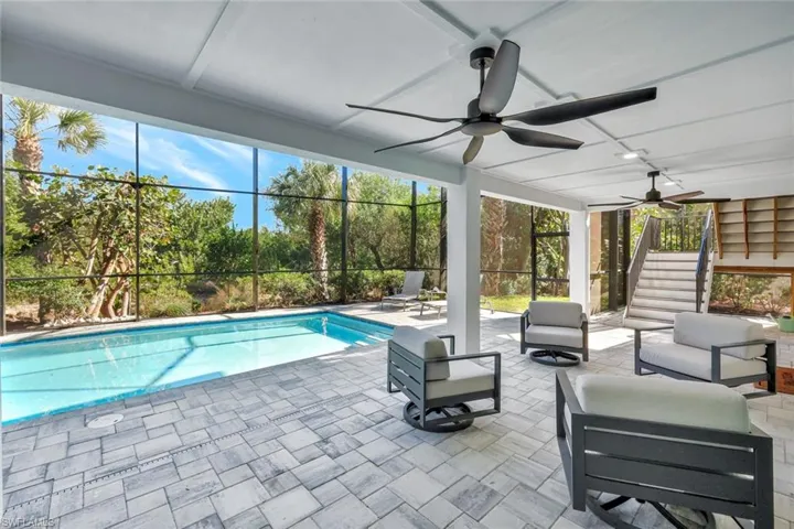 Swimming pool featuring a patio area, a lanai, an outdoor hangout area, and stairway