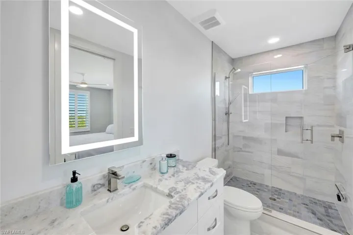 Full bathroom featuring vanity, a shower stall, ensuite bath, and recessed lighting