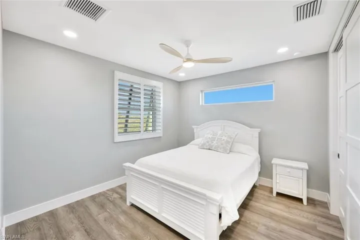 Bedroom with light wood-type flooring, ceiling fan, and recessed lighting