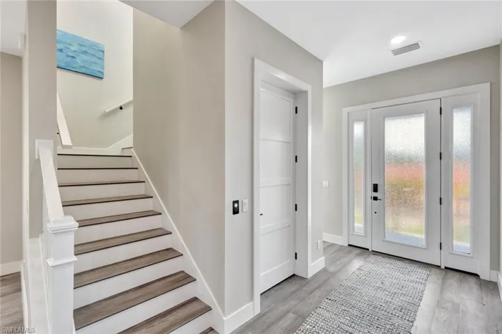 Entryway with light wood-style floors and stairway