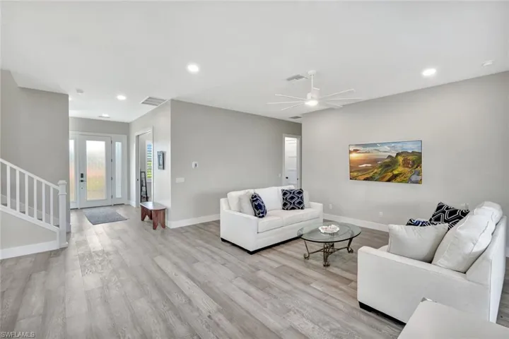 Living room featuring stairs, recessed lighting, light wood-type flooring, and a ceiling fan