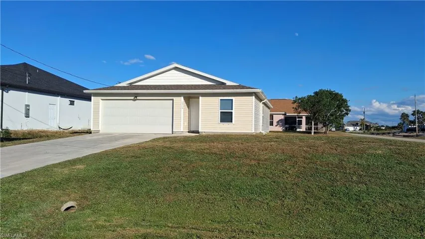 Ranch-style home with a front yard, driveway, and an attached garage