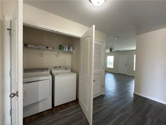 Laundry area featuring washing machine and dryer, dark wood-style floors, and ceiling fan