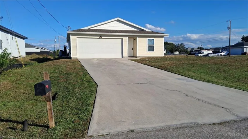 Ranch-style house featuring concrete driveway, a front yard, roof with shingles, and an attached garage