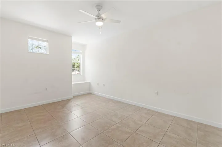 Neutral-toned tile flooring complements bright white walls and trim